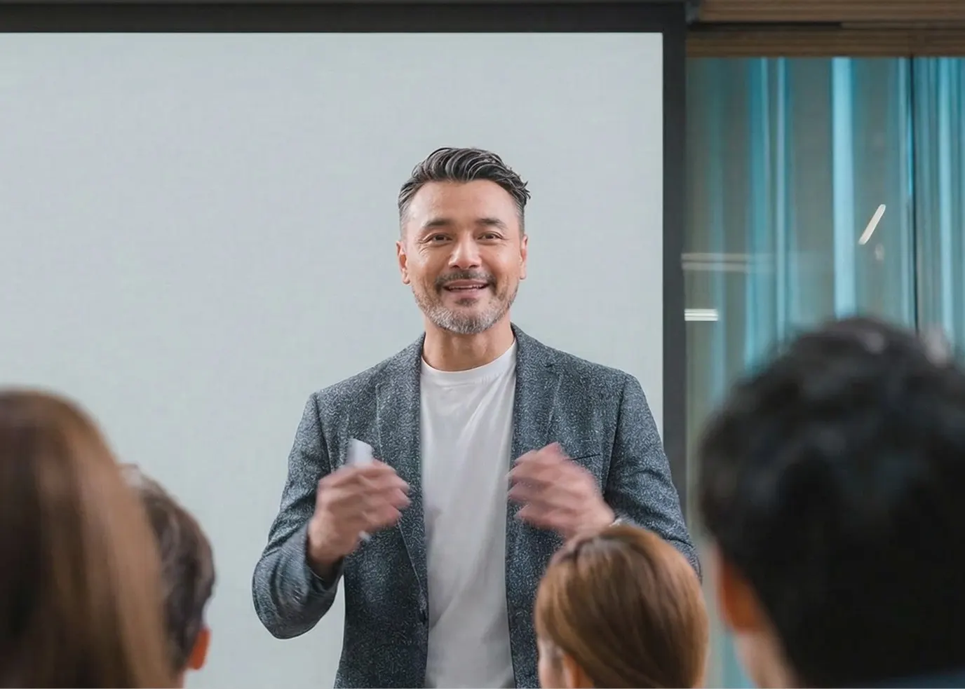 Trainer speaking to a seated audience during a public speaking course in Singapore