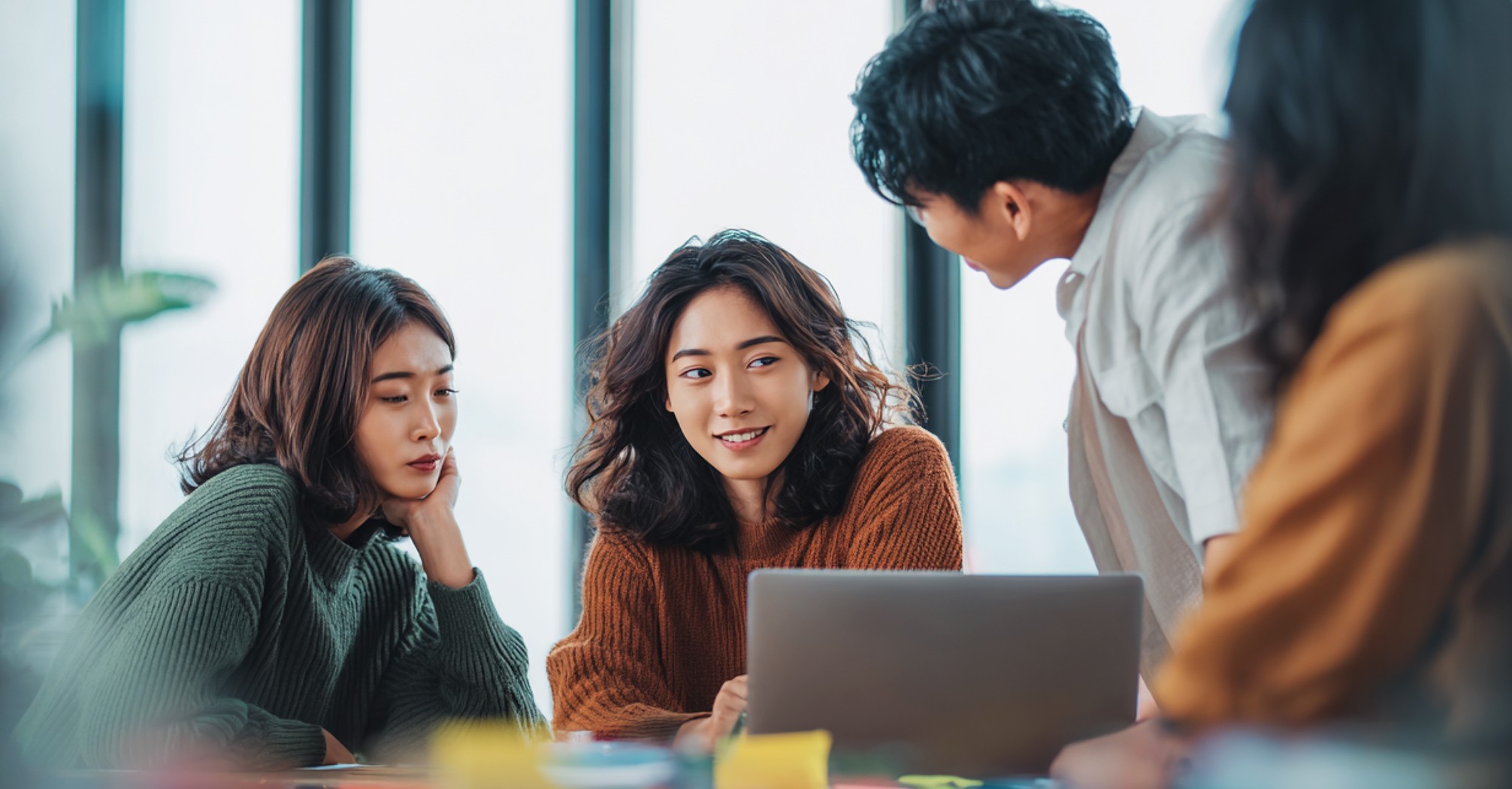 A team collaborating around a laptop